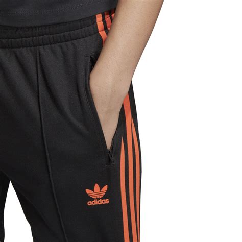 black and orange Adidas pants